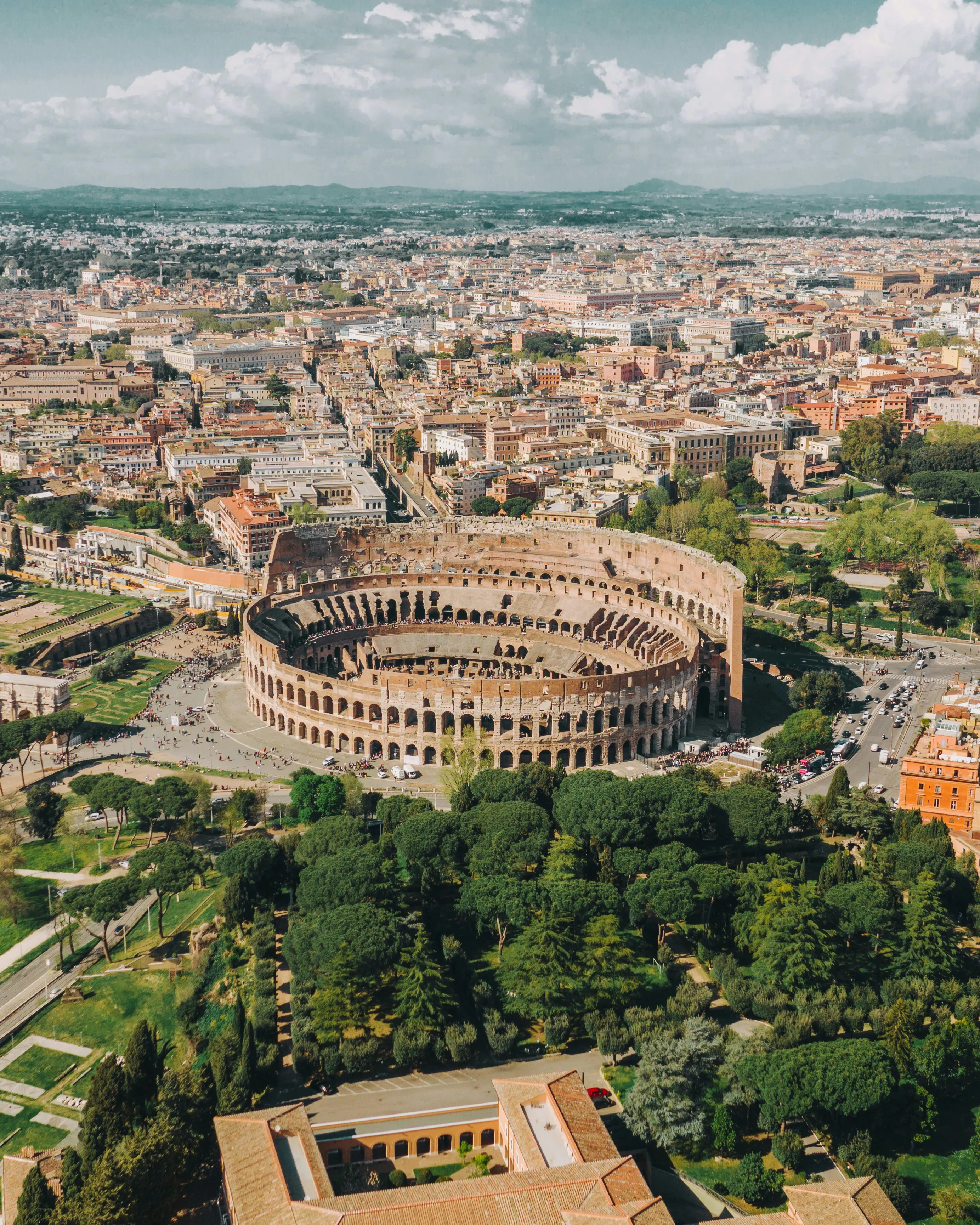 Aerial view of the Colosseum surrounded by Rome’s rooftops and parkland