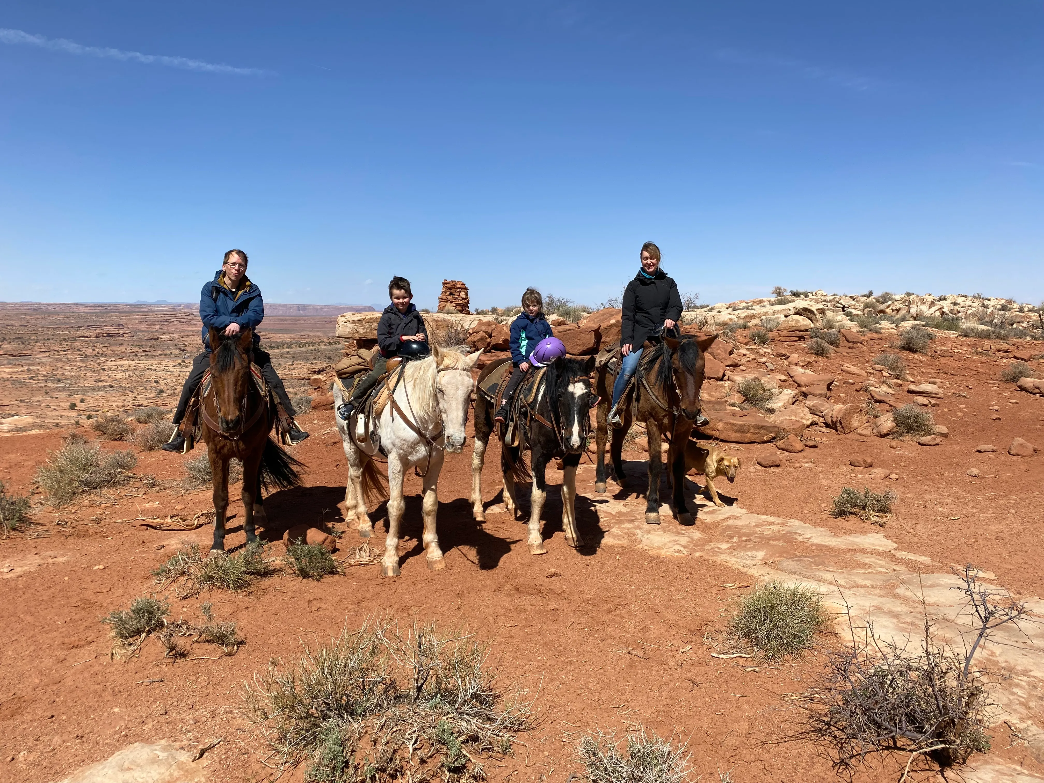 The family on horseback with the dog beside them during the Navajo horse riding excursion