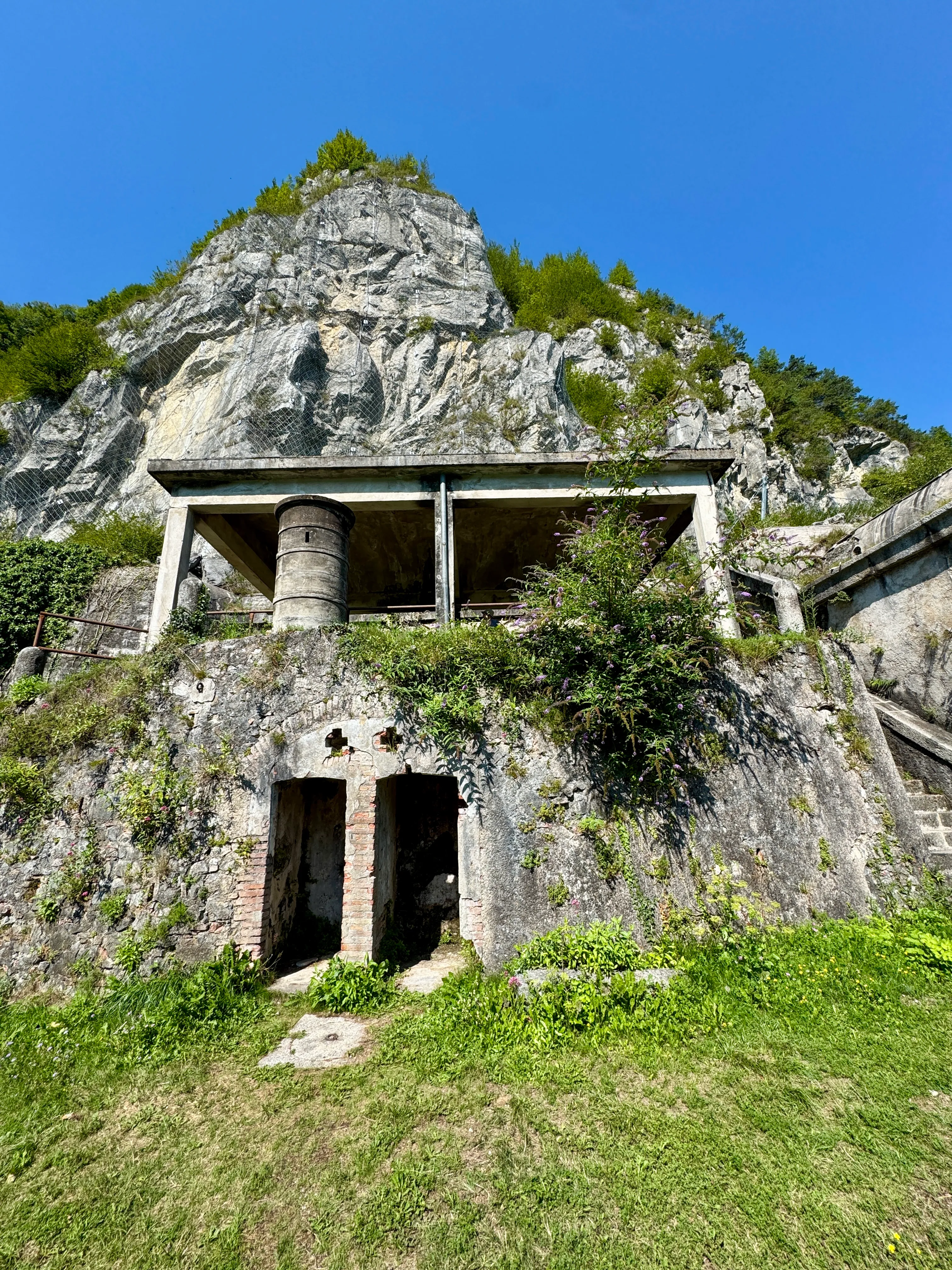 Ruined stone buildings of the Rocca d’Anfo fortress built into the mountainside above Lago d’Idro