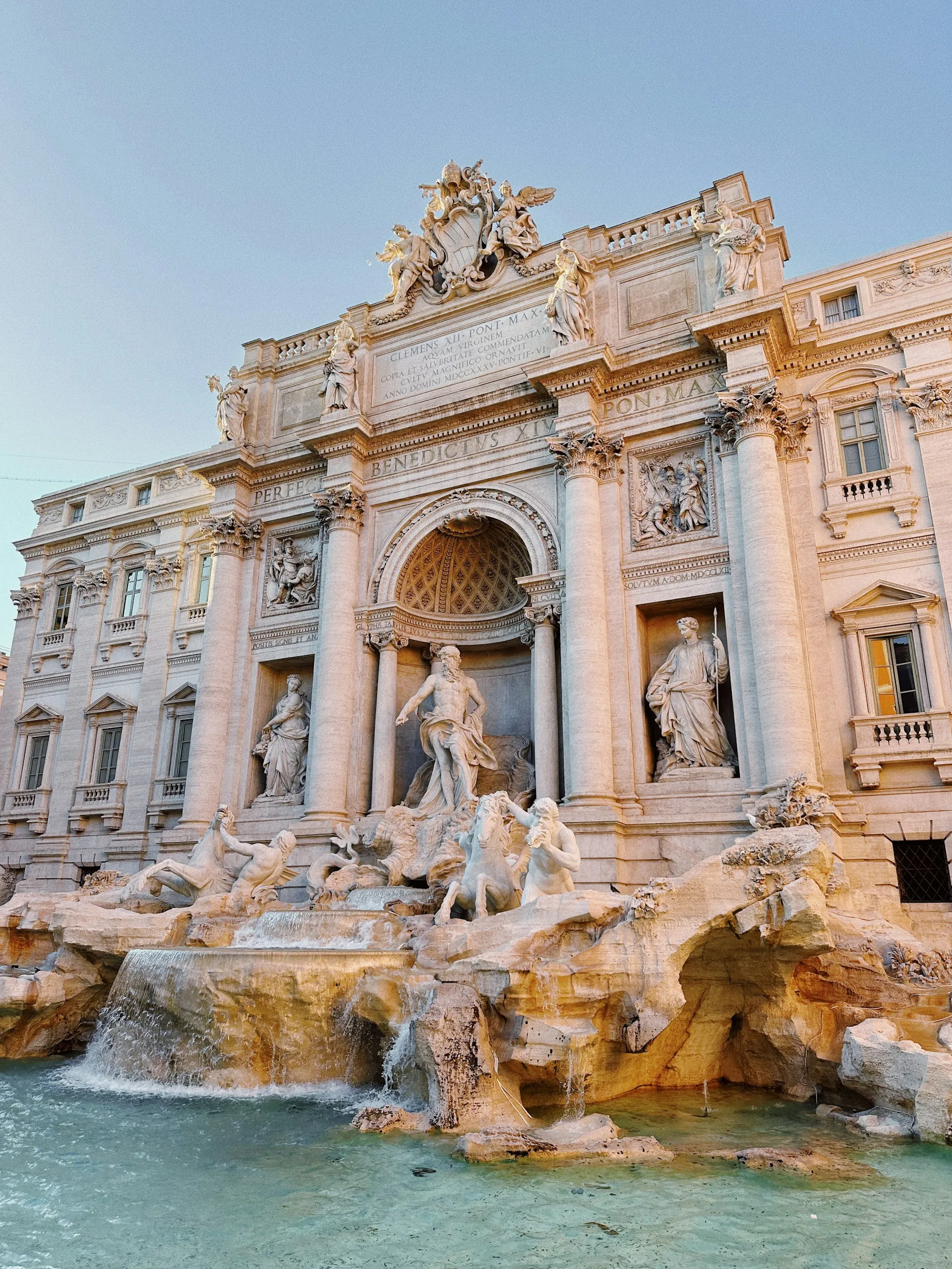 The Trevi Fountain in Rome, with its Baroque statues and cascading water lit at golden hour