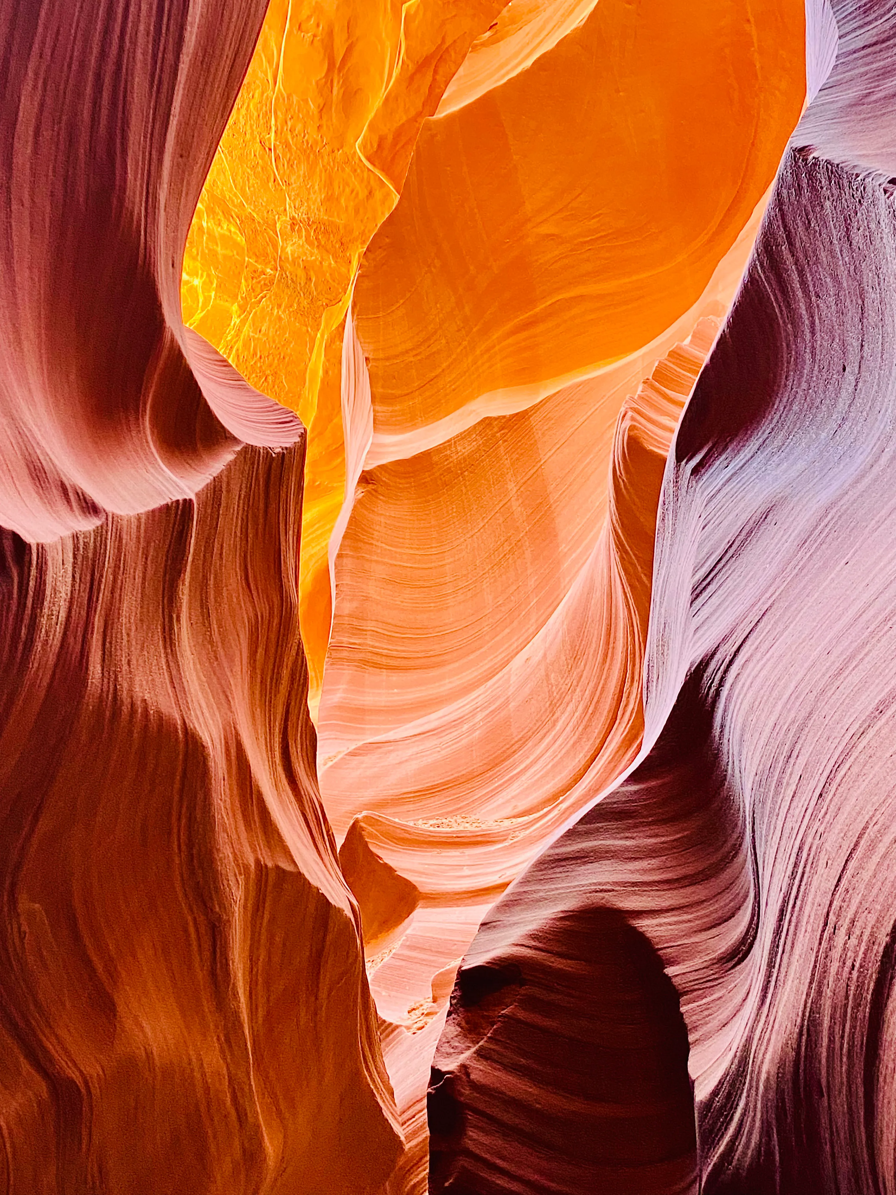 Swirling orange sandstone walls inside Antelope Canyon lit by a shaft of light