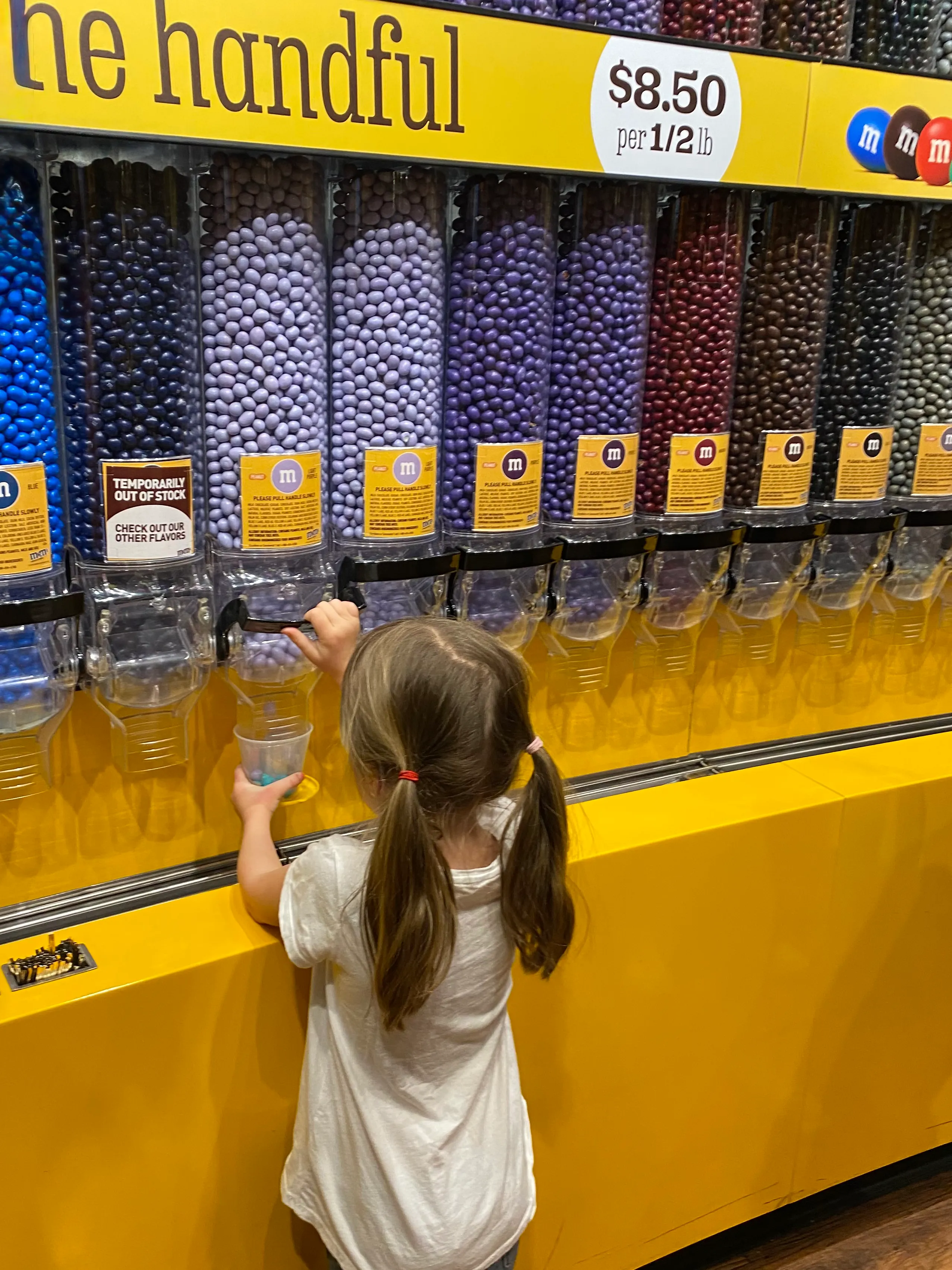 Sofia filling a cup with M&Ms at the M&M’s World store in Las Vegas