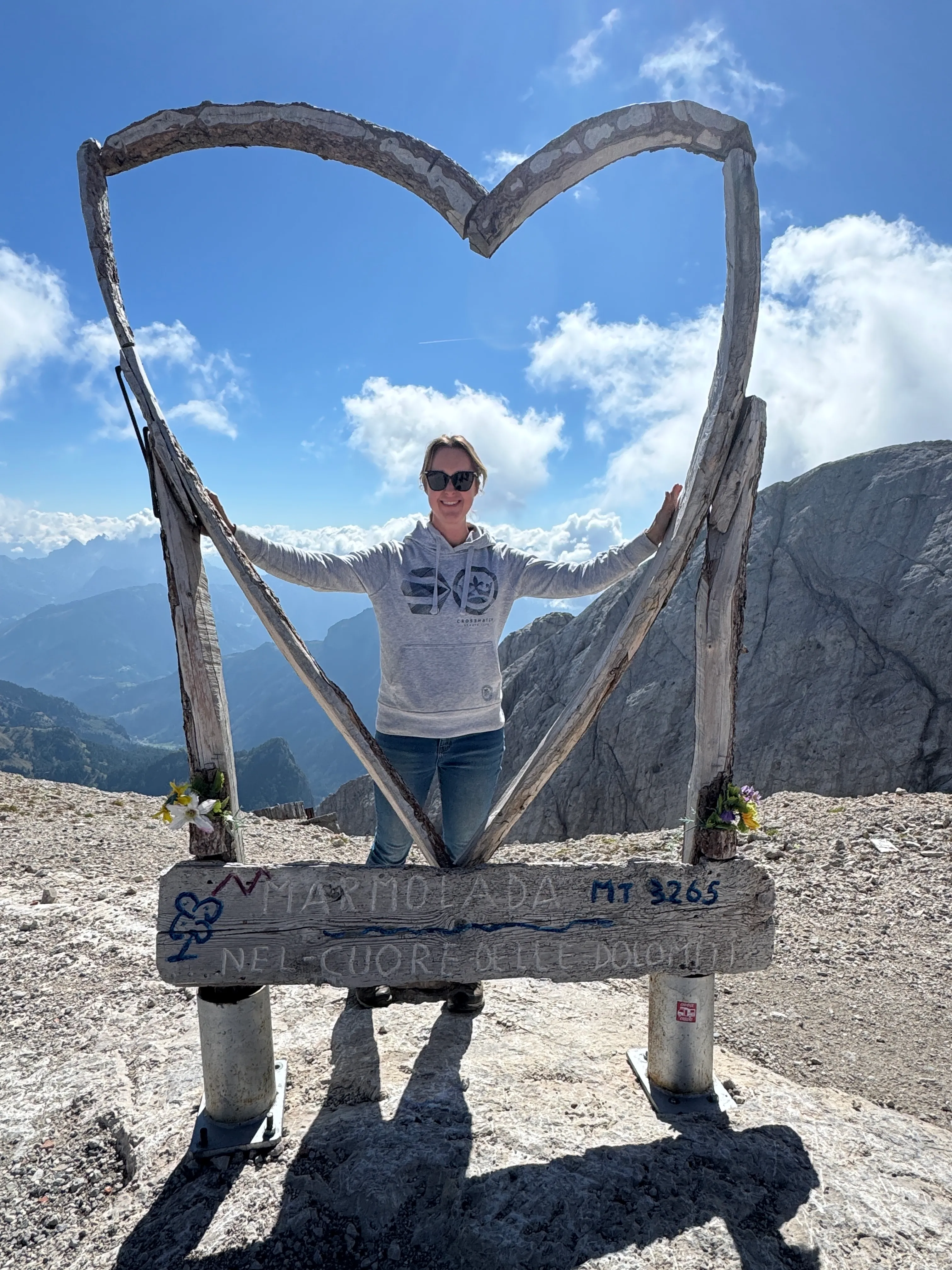 Standing inside a giant wooden heart-shaped sculpture at the Punta Rocca summit marker, 3,265 metres up on Marmolada