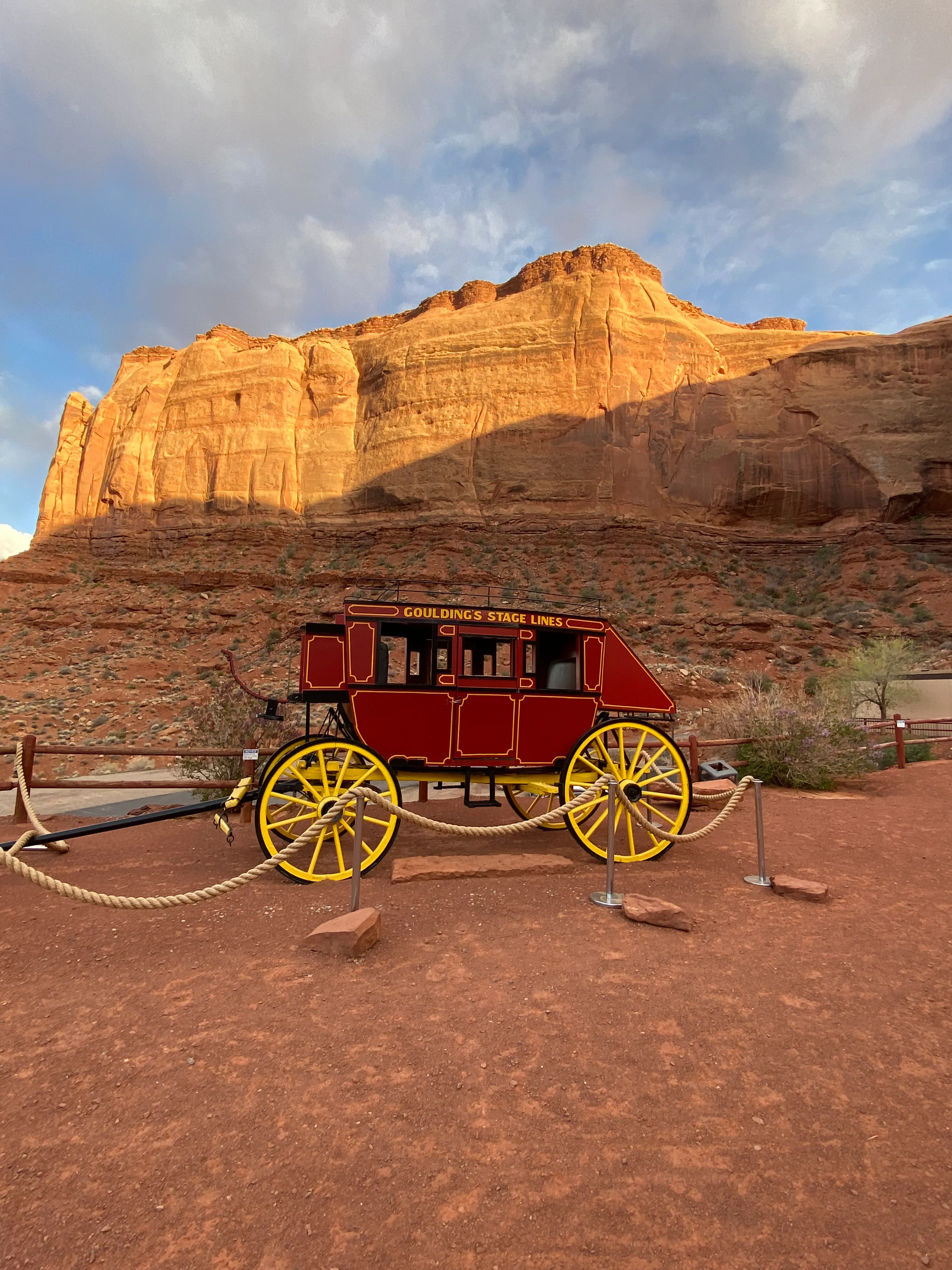 A vintage Goulding’s Stage Lines stagecoach on display against the Monument Valley cliffs